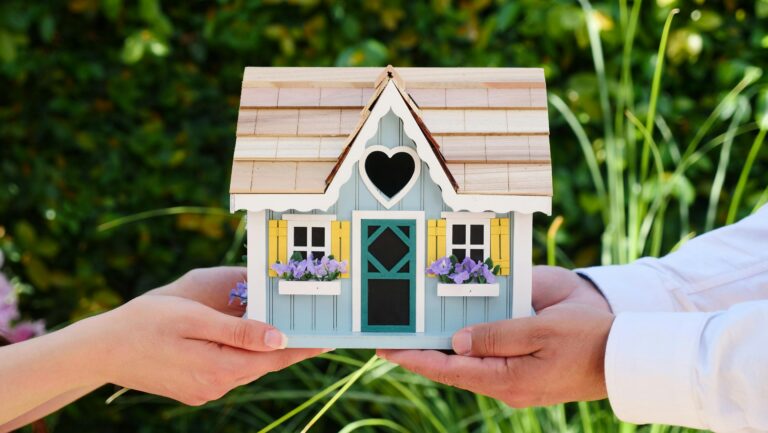 Two hands holding a model home
